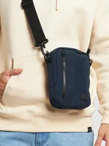 Bandolera azul de poliéster con correa ajustable negra y cierre de cremallera.