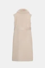 Chaleco largo de mezcla de lana color beige, de corte recto con manga sisa. Cuenta con cuello solapa con aplicación de pelo sintético extraíble, bolsillos laterales ocultos y un cinturón ajustable del mismo tejido para anudar en la cintura.