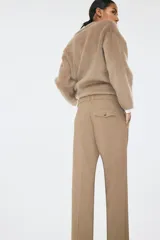Pantalón sastrero color marrón, de corte recto y tiro medio, con bolsillos laterales y pinzas delanteras.