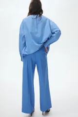 Pantalón sastrero de tiro alto con corte recto, pretina con cierre de botón y corchete oculto, bolsillo monedero con solapa y pliegues frontales.