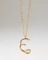 Collar dorado con cadena de eslabones y colgante en forma de la letra E, decorado con una circonita incrustada.