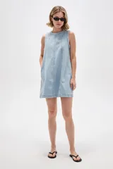 Vestido corto de jean sin mangas, con cuello redondo, diseño holgado y bolsillos laterales.