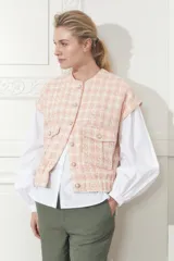 Chaleco de tweed color salmón con diseño a cuadros, sin mangas, con bolsillos frontales y botones perlados.