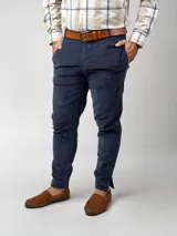 Pantalón de pana negro de corte recto, con bolsillos laterales y traseros. Se ajusta a la cintura con cinturón de cuero negro.