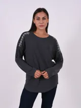 Blusa de punto gris oscuro con cuello redondo, manga larga y detalle de apliques brillantes en los hombros.