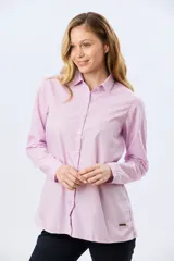 Camisa de manga larga de corte holgado, con diseño de rayas rosadas y blancas, cuello camisero y cierre frontal de botones.