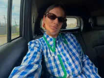 Camisa de manga larga con estampado de cuadros vichy en tonos azul y blanco, con cuello camisero grande, ribetes de crochet verde en cuello y botonera, y botones verdes.