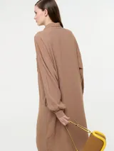 Vestido camisero negro de lino con botones delanteros y bolsillos ocultos.