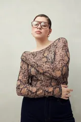 Top de manga larga de tejido translúcido con estampado floral en tonos marrones y negros.