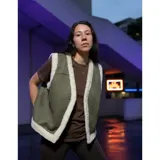 Chaleco estilo gamulán color verde militar con forro y bordes de corderito sintético blanco, diseño sin mangas.