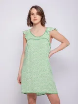 Vestido corto de viscosa color verde claro con estampado de flores blancas, sin mangas y con volados en los hombros.