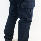 Pantalón cargo azul marino de gabardina con puño en los tobillos y múltiples bolsillos.