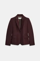 Blazer entallado color bordó con hombreras, solapas clásicas, bolsillos delanteros con solapa y cierre frontal de un botón.