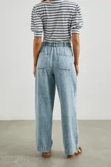 Pantalón de jean celeste de corte holgado, con cintura elástica ajustable con cordón, bolsillos laterales y traseros.
