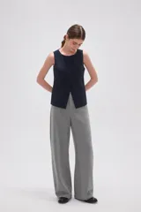 Chaleco sin mangas de corte sastrero, color marrón con diseño de rayas verticales finas. Presenta cuello redondo, cierre frontal con botones y dos bolsillos laterales simulados.