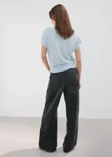 Chaleco de tejido de punto fino color celeste con sutiles lentejuelas, cuello polo y cierre delantero parcial con botones.