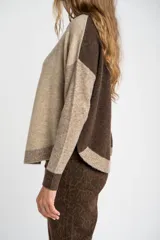 Sweater de punto con diseño color block en tonos beige, marrón y bordó, de cuello redondo y manga larga con puños acanalados en contraste.