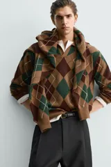 Polo de punto de corte relajado, con estampado de rombos en tonos marrón y verde. Presenta cuello solapa con abertura frontal, manga larga y acabados en rib.