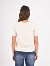 Remera básica de cuello redondo y manga corta, confeccionada en algodón color crema, con corte recto y ajuste cómodo.