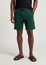 Bermudas de felpa verde oscuro, con corte recto y cordón ajustable en la cintura.