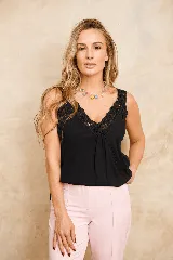 Musculosa de seda negra con escote en V y detalles de encaje floral en el escote y los tirantes.