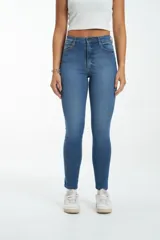 Pantalón de jean azul de tiro alto, corte ajustado y largo al tobillo.