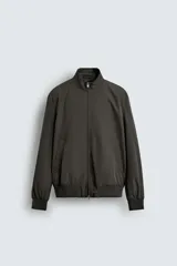 Cazadora de corte regular confeccionada en tejido técnico repelente al agua. Presenta cuello subido, manga larga con puños de rib, bolsillos laterales de vivo y cierre frontal con cremallera.