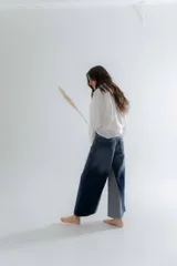 Jean de corte oxford con tiro medio-alto, confeccionado en algodón. Presenta un diseño de paneles con cortes verticales en dos tonos de azul y costuras marcadas en las piernas, ofreciendo una silueta amplia y fluida.