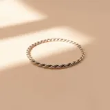 Esclava rígida de diseño trenzado, confeccionada en plata 925 con acabado brillante.