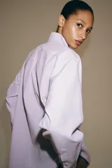 Camisa de manga larga confeccionada en hilatura con mezcla de algodón, con cuello solapa, bajo redondeado y cierre frontal oculto con botones.