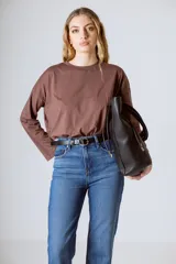 Camiseta de manga larga color marrón, confeccionada en algodón orgánico, con cuello redondo y detalle de letra R bordada en el pecho.