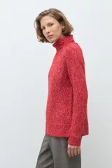 Polerón de cuello alto confeccionado en tejido buclé con textura jaspeada, de corte holgado y mangas largas con diseño raglán.