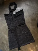 Top negro de tejido lurex con escote halter y lazo al cuello.