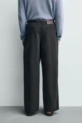 Pantalón de corte wide fit confeccionado en algodón con efecto lavado. Presenta pliegues frontales, bolsillos laterales y bolsillos traseros de vivo. Cierre frontal con cremallera y gancho metálico oculto.