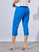 Pantalón capri de gabardina elastizada color celeste, con bolsillos simulados delanteros y bolsillos aplicados traseros. Tiene pretina ancha, corte recto y detalle calado en el ruedo.