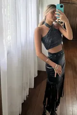 Falda midi negra de gabardina metalizada elastizada, con tachas en la cintura y flecos en el ruedo.