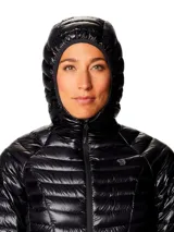 Campera puffer ultraligera de color negro con capucha, marca Mountain Hardwear modelo Ghost Whisperer. Presenta tejido ripstop, aislamiento de plumón, cierre frontal completo y bolsillos laterales con cremallera.