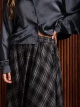 Pollera larga de corte amplio y voluminoso, con estampado de cuadros escoceses en tonos azul marino y amarillo. Presenta cintura elástica y bolsillos laterales.