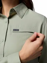 Camisa de manga larga Columbia, color verde claro, con cuello clásico, cierre frontal de botones y bolsillo pequeño en el pecho con logo de la marca.