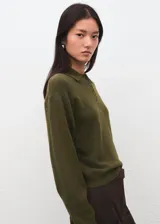 Jersey verde militar con cuello polo y cierre frontal de botones, manga larga y diseño ajustado.