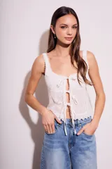 Blusa blanca de algodón con escote cuadrado, breteles anchos con detalle de puntilla y lazos ajustables en el frente.