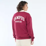 Remera estilo rugby de manga larga en color bordó, con cuello tipo polo en contraste color crema y cierre frontal con botones. Presenta estampado gráfico universitario en el pecho.