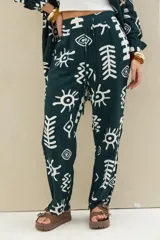 Pantalón verde oscuro con estampado abstracto en color blanco, de corte holgado y cintura elástica con cordón ajustable.