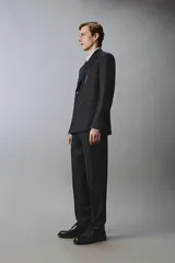Blazer de corte regular fit confeccionado en lana italiana, con diseño de raya diplomática. Presenta cuello con solapas de pico, cierre frontal de botonadura cruzada, bolsillos de vivo en el pecho y bolsillos de solapa en la cadera.
