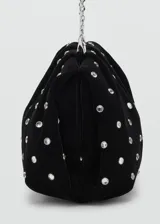 Bolso de mano negro de terciopelo, decorado con pedrería plateada distribuida en toda la superficie y cierre superior.