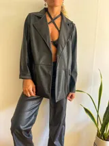 Blazer negro con textura símil cuero de cocodrilo, corte recto y solapas clásicas.