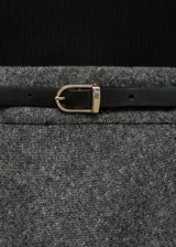 Vestido midi de diseño combinado con cuerpo de punto negro de cuello alto y manga corta, y falda evasé de tejido jaspeado en color gris. Incluye un cinturón fino negro con hebilla metálica.