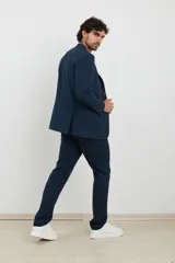 Saco azul oscuro con solapa de muesca, cierre de dos botones, dos bolsillos delanteros con solapa y un bolsillo en el pecho. Corte clásico.