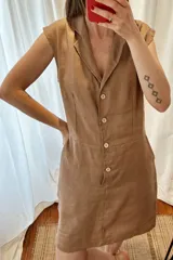 Vestido corto de lino y algodón color tostado, sin mangas, con cuello solapa y cierre frontal de botones.