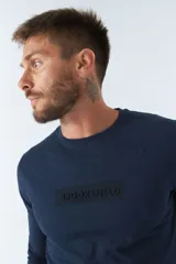 Remera básica de hombre color azul marino, de manga larga, con cuello redondo y logo estampado en el pecho.